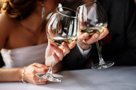 Bride and groom holding wine glasses.