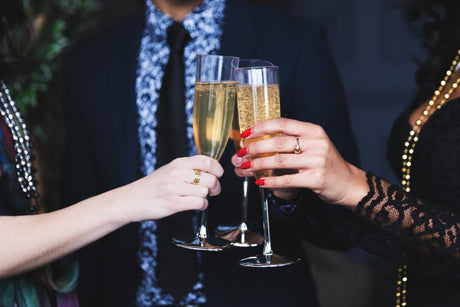 Three flutes raised in a toast, filled with sparkling champagne, celebrating a special occasion.