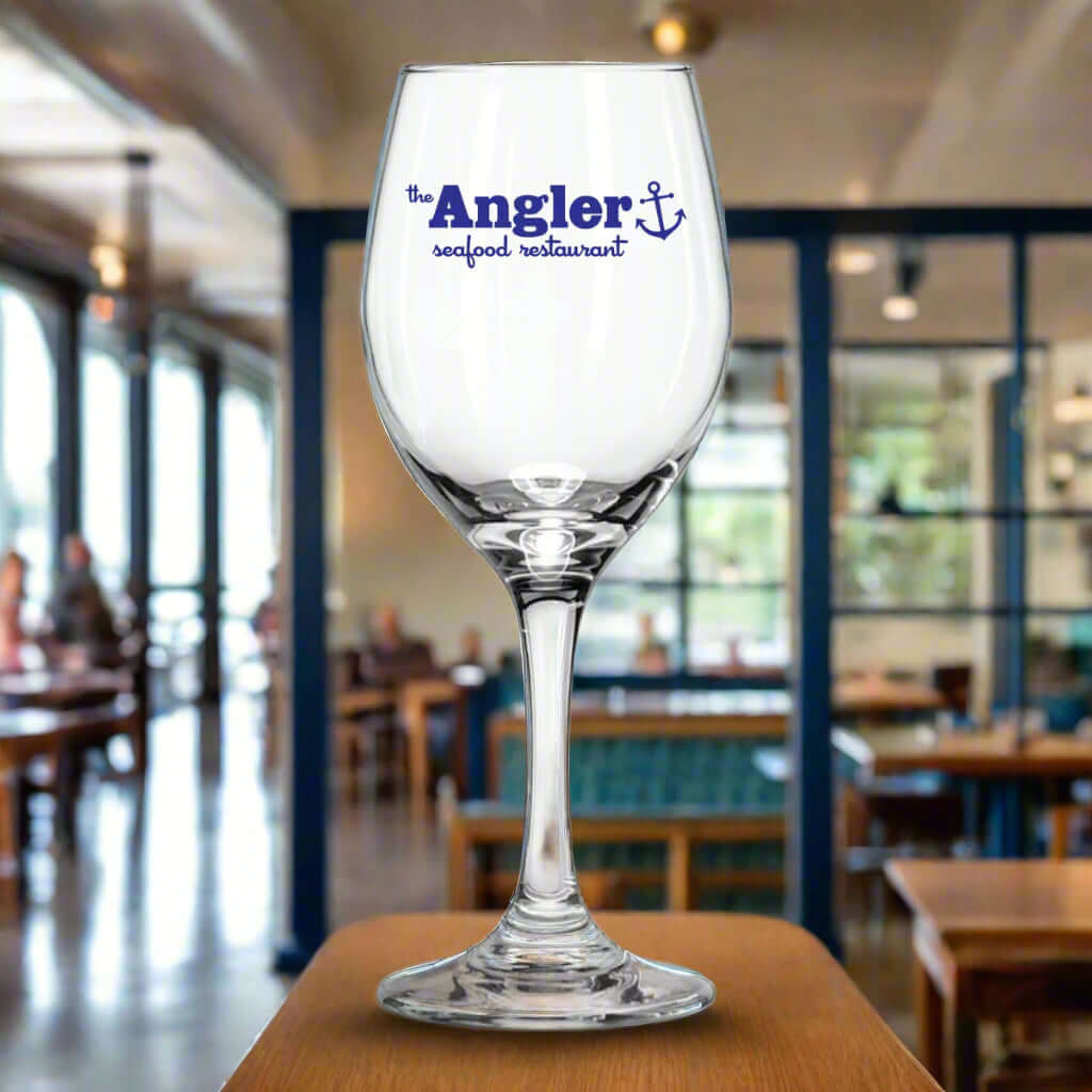 Custom Angler seafood restaurant wine glass displayed in a stylish dining setting.