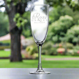 Custom Arc 5.75 oz Nuance Flute Wine Glass with Rose Garden Ballroom branding in a garden setting.